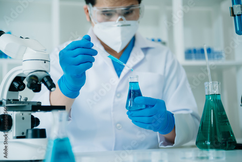Male scientist researcher conducting an experiment working in chemical laboratory