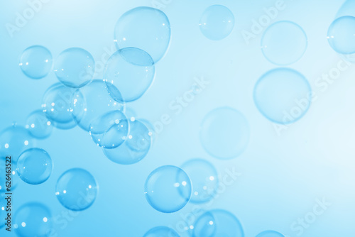 Beautiful Transparent Blue Soap Bubbles Floating in The Air. Abstract Blurred Background. Celebration Festive Backdrop. Refreshing of Soap Suds  Bubbles Water.  