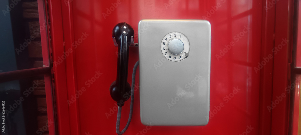 grey old Soviet payphone. telephone hanging inside red booth. grey old Soviet payphone. telephone hanging inside red booth.