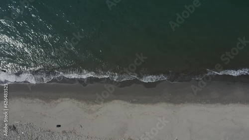 ドローン撮影：晴れの日、砂浜に打ち寄せる波