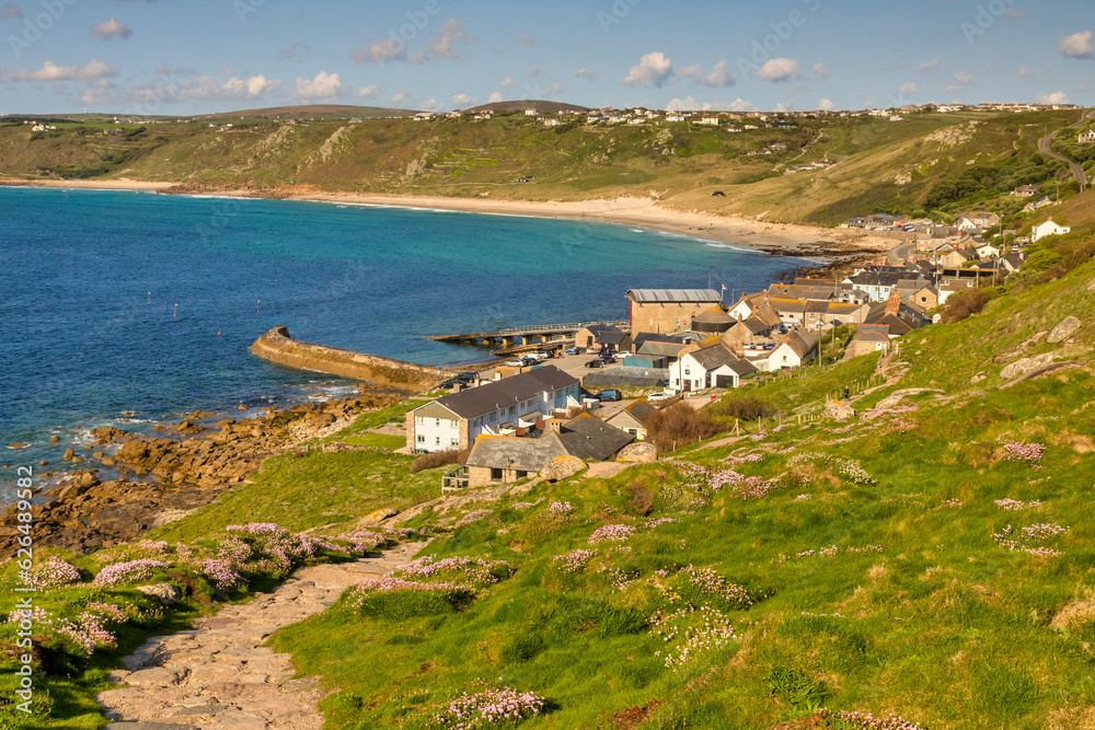 Sennen Cove, near Land's End, Cornwall, on a sunny spring evening, with sea thrift in bloom on the hillside. The path is the start of the walk to Land's End.