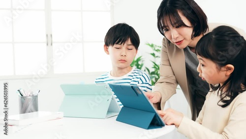 タブレットで勉強する子供たちと教える女性 photo