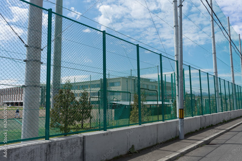 Obraz premium 学校の部活と高いフェンス