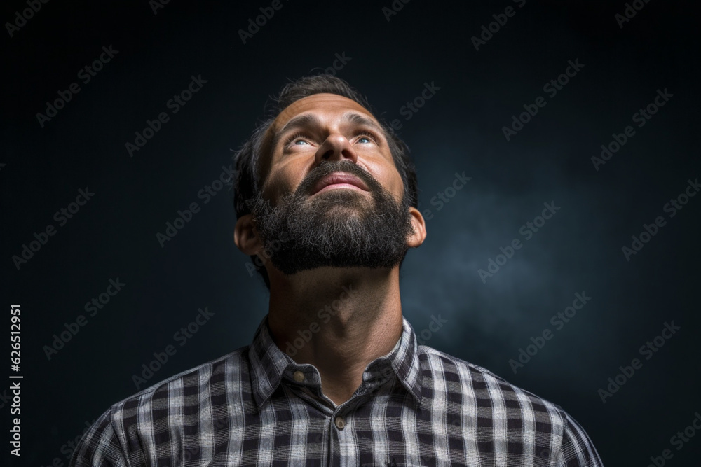 Facet portrait a man looking up, Dark lighting portrait bristle men in checkered shirt looks up with his head up on a dark gray background copy space
