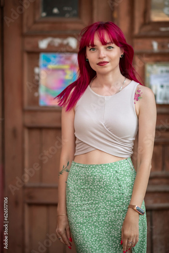 Portrait of a beautiful young girl with red hair, in an urban environment.