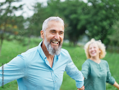 woman man couple happy together mature active bonding love outdoor run running portrait walking leisure park fun smiling park old nature wife happiness senior people mid middle adult vitality