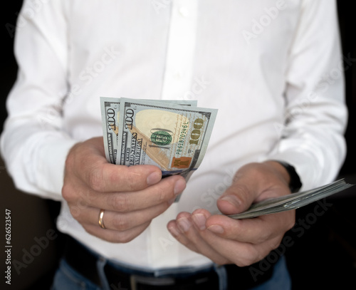Close up male hand Counting and holding money us dollar.
