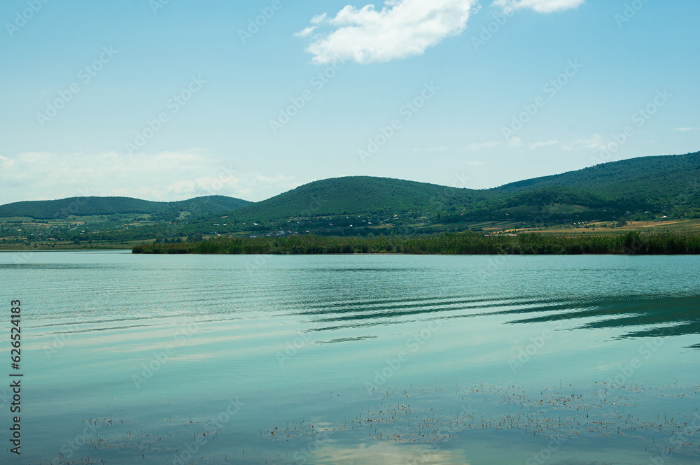 blue lake, mountains and blue sky with white clouds in summertime