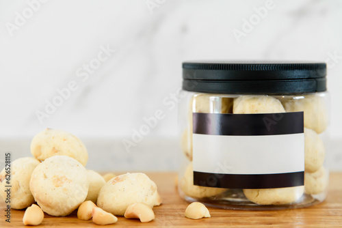 Macadamia nut and cookies in plastic cans on wooden table