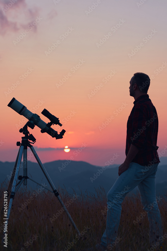 Astronomer looking at the skies with a telescope.