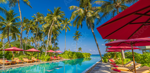 Panoramic holiday landscape. Luxury beach poolside resort hotel swimming pool, beach chairs beds umbrellas palm trees, relax lifestyle, blue sunny sky. Summer island seaside, leisure travel vacation