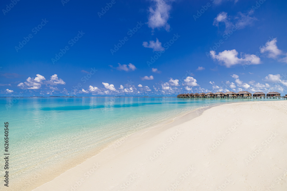 Maldives island, luxury water villas resort. Beautiful blue sunshine sky closeup ocean waves lagoon beach background. Summer vacation wallpaper and travel concept. Paradise panoramic coast landscape