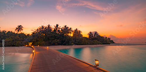 Fototapeta Naklejka Na Ścianę i Meble -  Sunset on Maldives island, luxury water villas resort, wooden pier. Beautiful sky clouds and beach coast background. Summer vacation landscape, palm trees silhouette led lights. Amazing destination