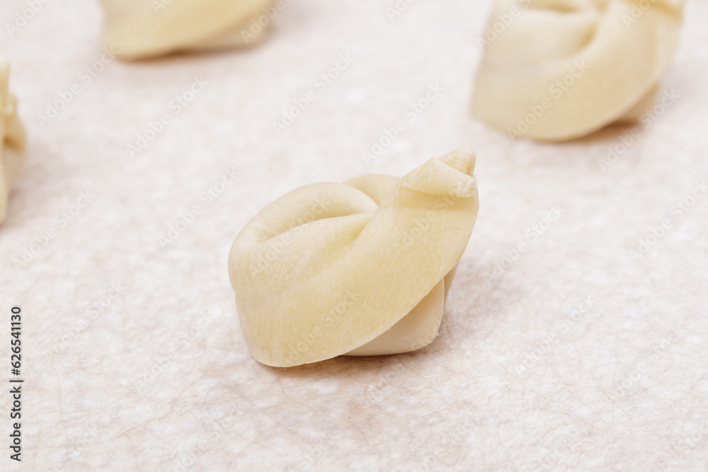 Uncooked dumplings on white table closeup. Homemade dumplings. Uncooked dumplings on white table closeup. Homemade dumplings.