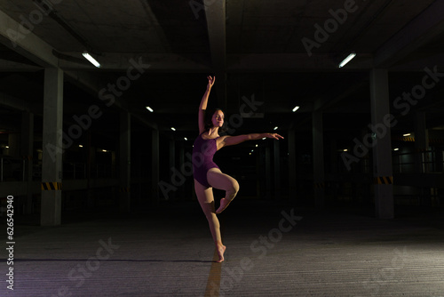 Attractive female ballet dancer dancing in the parking lot