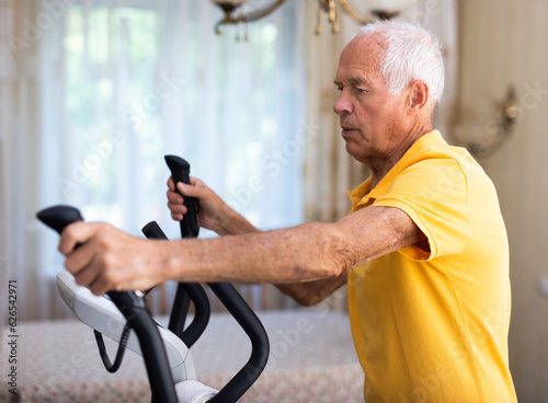 Male is working out on elliptical machine for elder healthy concept