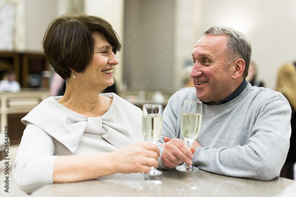 Mature man and woman drinking champagne in theater lobby Mature man and woman drinking champagne in theater lobby