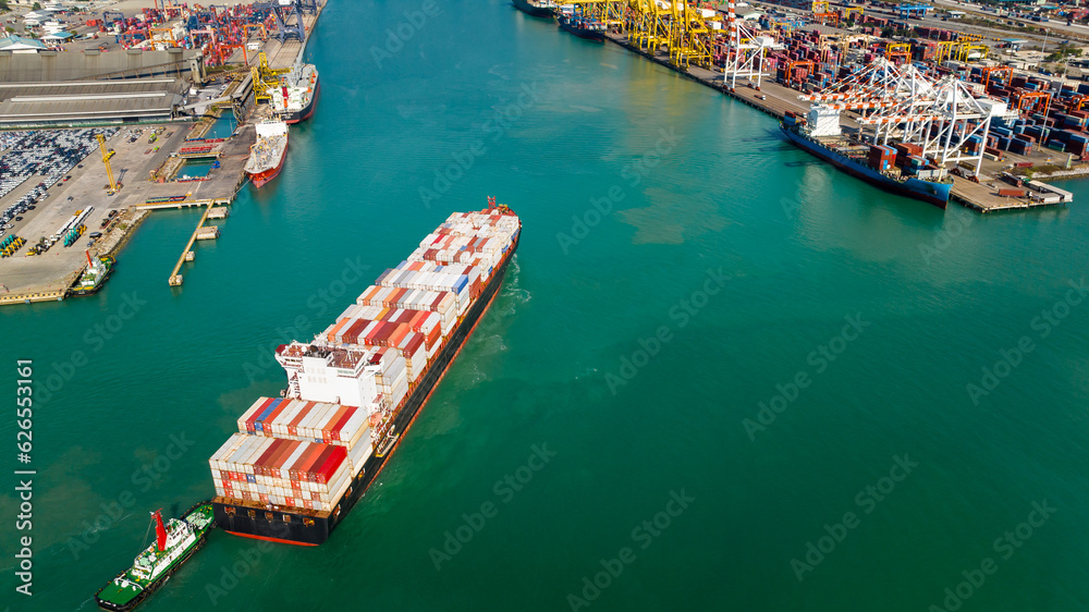 Fototapeta premium container ship and shipping port loading and unloading cargo from container ship import and export by crane for distributing goods by trailers transported to customers and dealers, aerial view