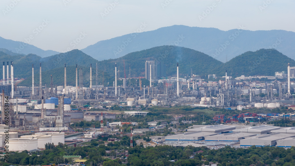 Oil refinery plant industry factory zone, oil and gas petrochemical industrial, oil storage tank and pipeline steel on island and moundtainbackground, aerial view
