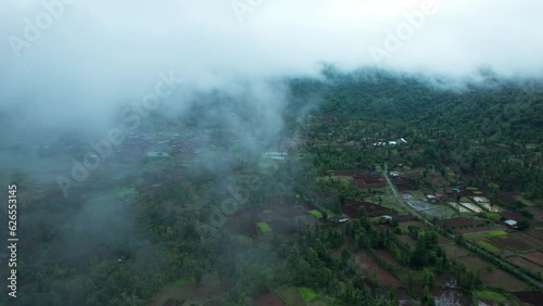 4K aerial view of Flying through rain clouds above green mountain covered by jungle and small villages at Saputara, Dang, India. Wonderful rainy day. Natural landscape photo