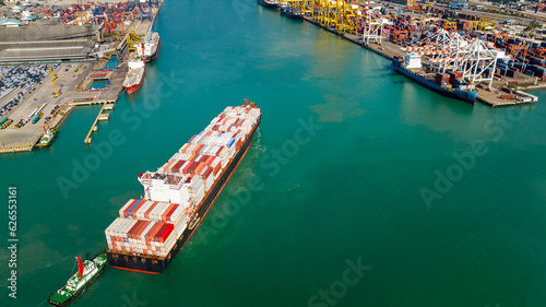 container ship and shipping port loading and unloading cargo from container ship import and export by crane for distributing goods by trailers transported to customers and dealers, aerial view