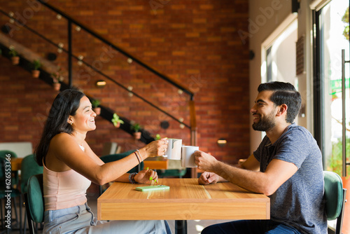 Cheerful couple talking and having fun while drinking coffee