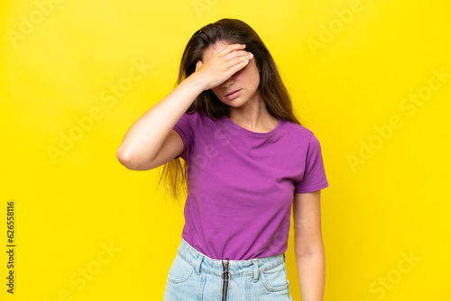 Young caucasian woman isolated on yellow background with headache