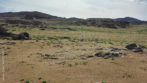 Aerial view on rock formations and stacked stones on granite hilltops, Baga Gazriin Chuluu, Gobi desert, Mongolia, 4k photo