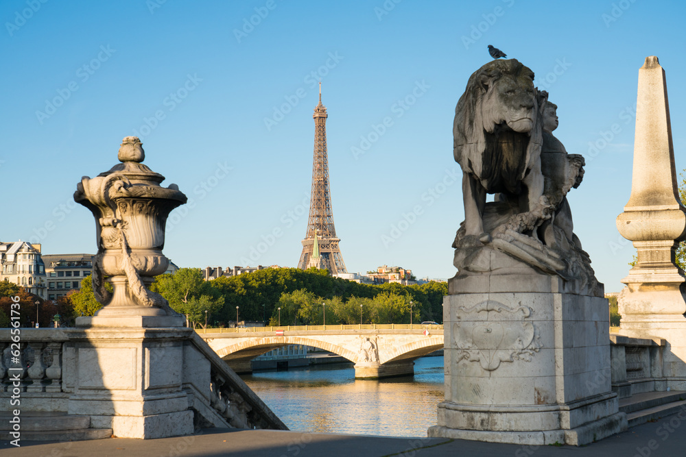 View of Eiffel Tower from Pont Alexandre III bridge in morning sunlight.  Eiffel Tower is one of the most iconic landmarks of Paris