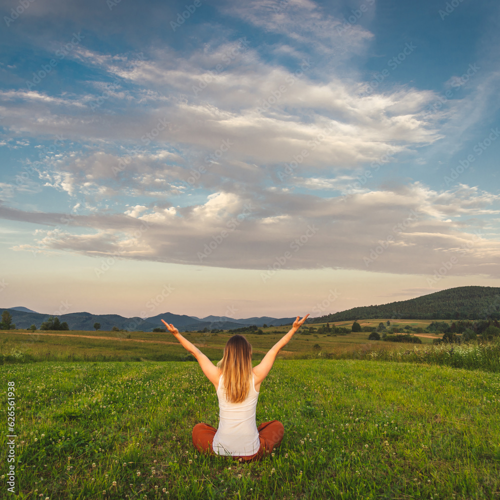 Woman doing yoga on the green grass at the mountain. Carpathians Woman doing yoga on the green grass at the mountain. Carpathians
