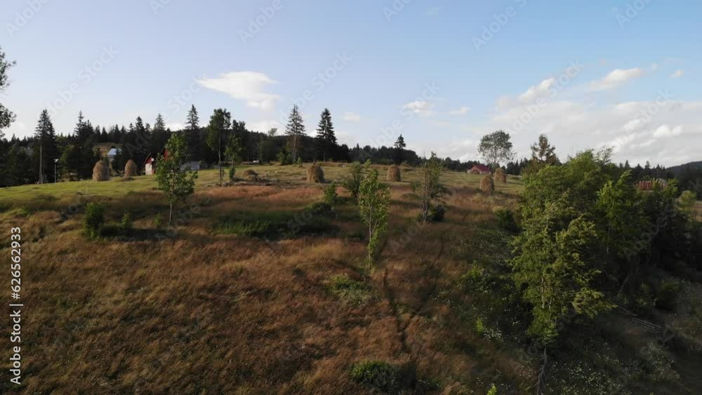 Aerial landscape view of village on hill with clouds, trees and mountain Aerial landscape view of village on hill with clouds, trees and mountain