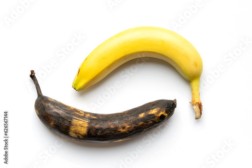Reife gelbe Banane und überreife braune Banane vor weissen Hintergrund mit Schatten