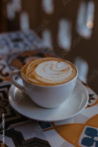 Large cappuccino in a white mug on a table with tiles