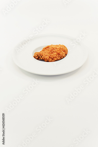 immagine primo piano di petto di pollo impanato e fritto su piatto da portata bianco, sfondo superficie bianca