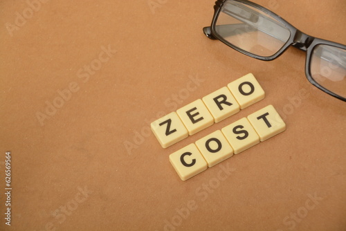 Eyeglasses and alphabet letters with text ZERO COST. Copy space. photo