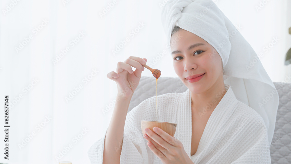 Young woman in bathrobe enjoying honey skin spa. Young woman in bathrobe enjoying honey skin spa.