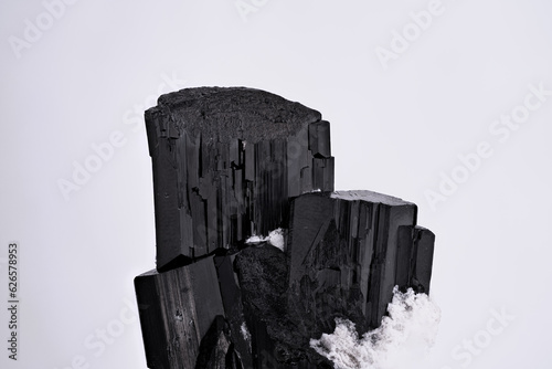 Fotografie Schorl (black tourmaline) crystal on white background