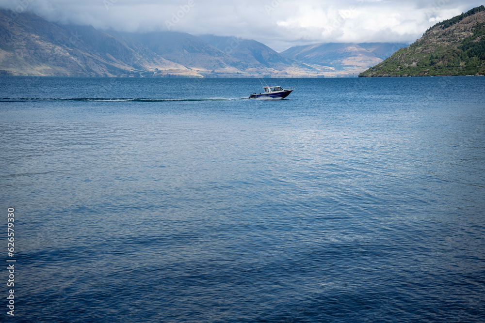 A small boat sailing in Lake Wakatipu. Lake view of Lake Wakatipu, Queenstown, New Zealand.