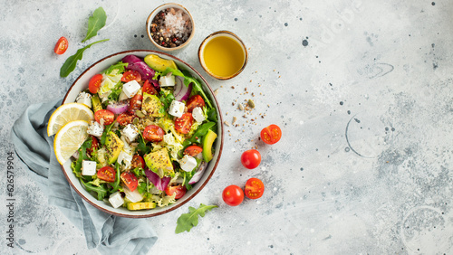Fotografie Delicious and healthy green salad of different leaves and vegetables with seeds and olive oil