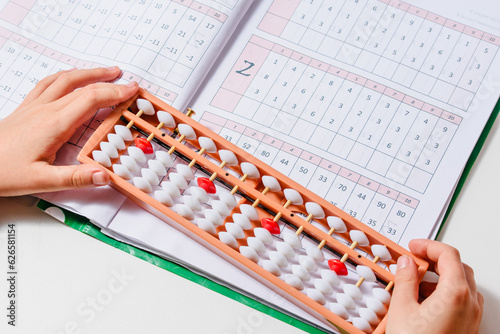 Japanese traditional abacus soroban isolated on white background. Child Hand using abacus. Education and development concept. Back to school  math education  mental mathematics  arithmetic
