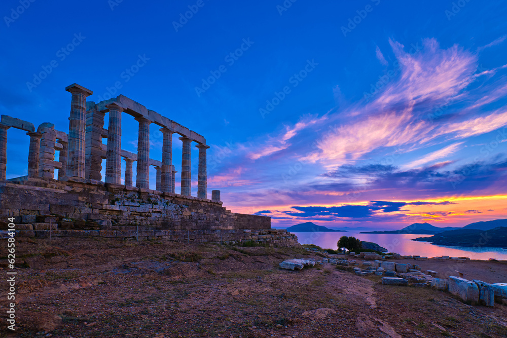 Sunset sky and ancient ruins of temple of Poseidon, Sounion, Greece