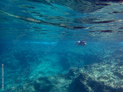 Vista subacquea di una donna che fa snorkeling nel mare del Plemmirio