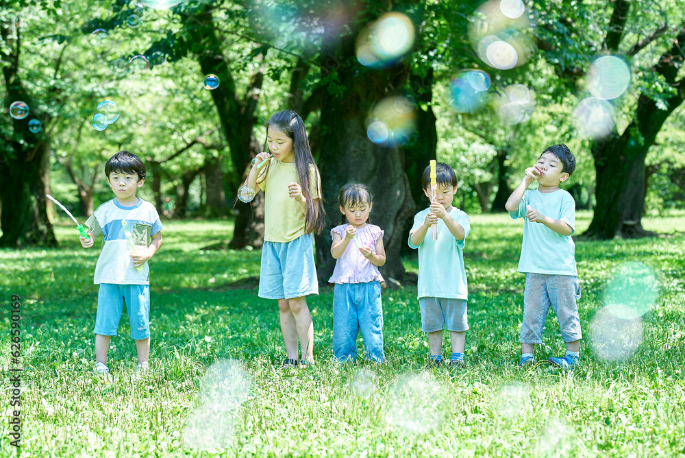 Obraz premium シャボン玉をして遊ぶ子供たち