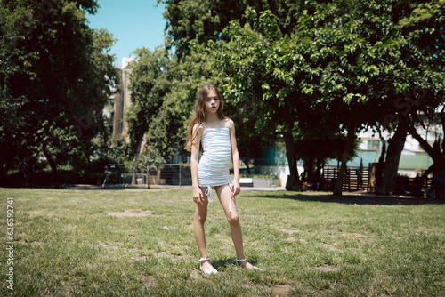 Girl with white dress standing outside in the park Ten-year-old Great for fashion and lifestyle concept