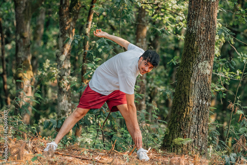 young sporty man warming up or stretching outdoors, exercising