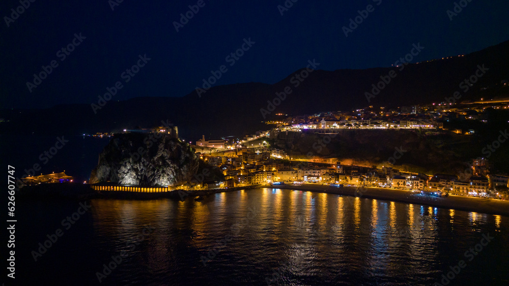 Italy, July 2023: night aerial view from the drone of the medieval village of Scilla in Calabria, with its castle, tourist port and beaches with restaurants