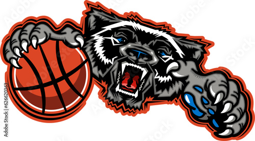 mean wolverine mascot holding basketball for school, college or league sports photo