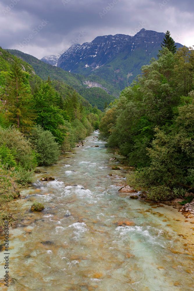 Obraz premium Majestic turquoise Soca river in the green forest, Bovec, Slovenia, Europe. Beautiful rafting and kayaking place in Europe. Great recreation place and kayaking destination. 