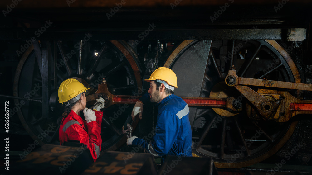 Obraz premium Industrial engineers inspect and perform maintenance on the machines at factory machines. Efficient Machinery Operation and Teamwork in the Manufacturing Industry