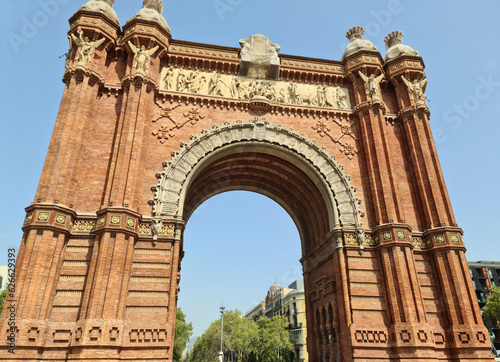 Barcelona, Spain - 22 July 2023: The Arc de Triomf in Barcelona on a sunny day with some tourists photo
